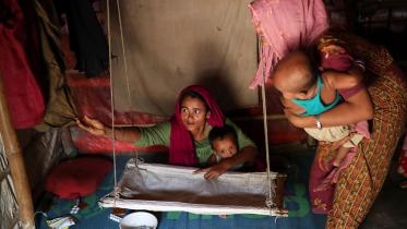 Rohingya refugee women arrange a cradle for child