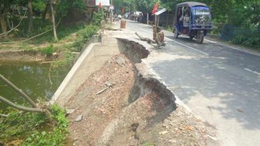 The soil and pitch road next to the bridge broke down and mixed with the canal water in Jashore.jpg